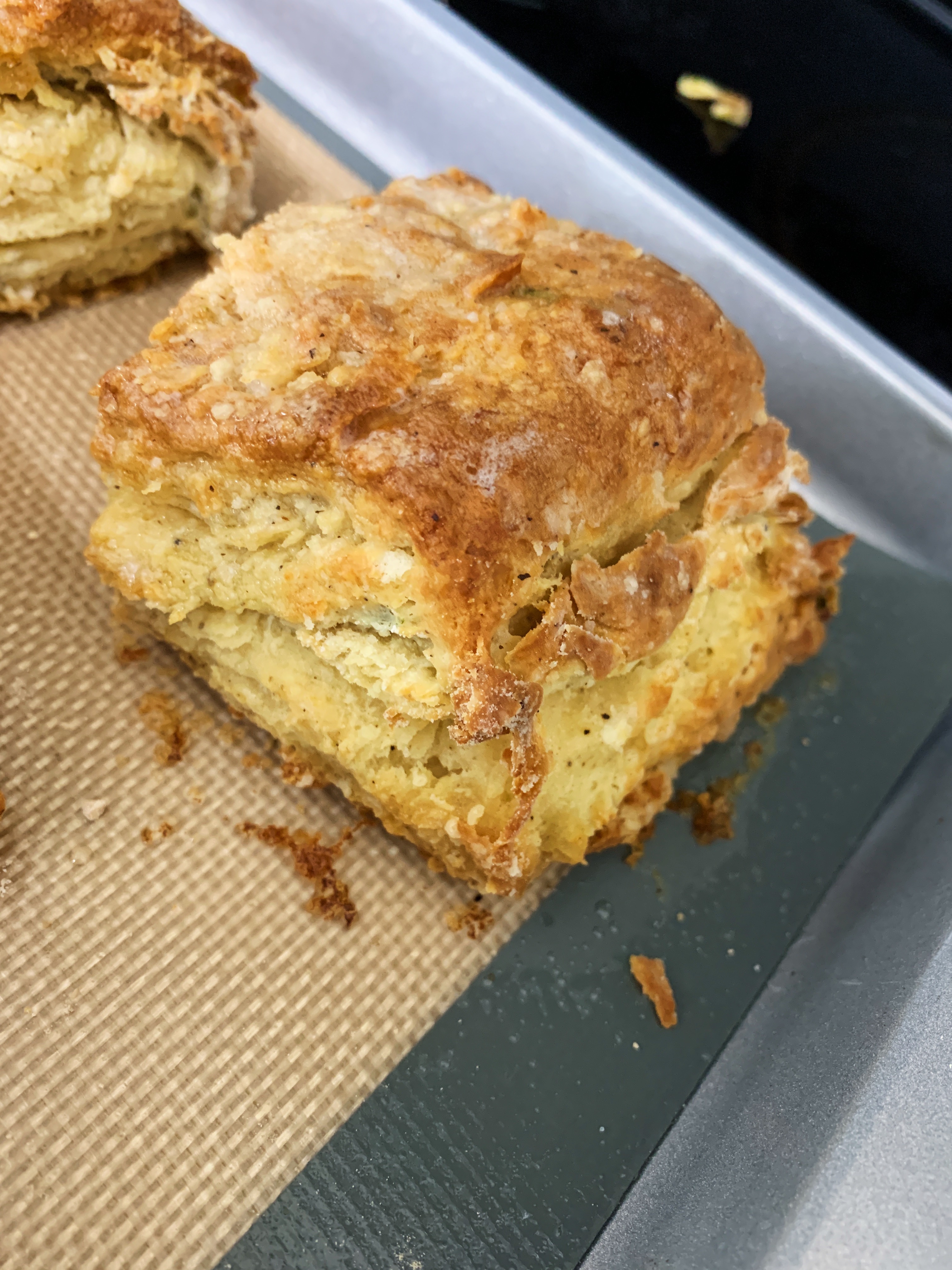A flaky, golden homemade biscuit on a baking sheet